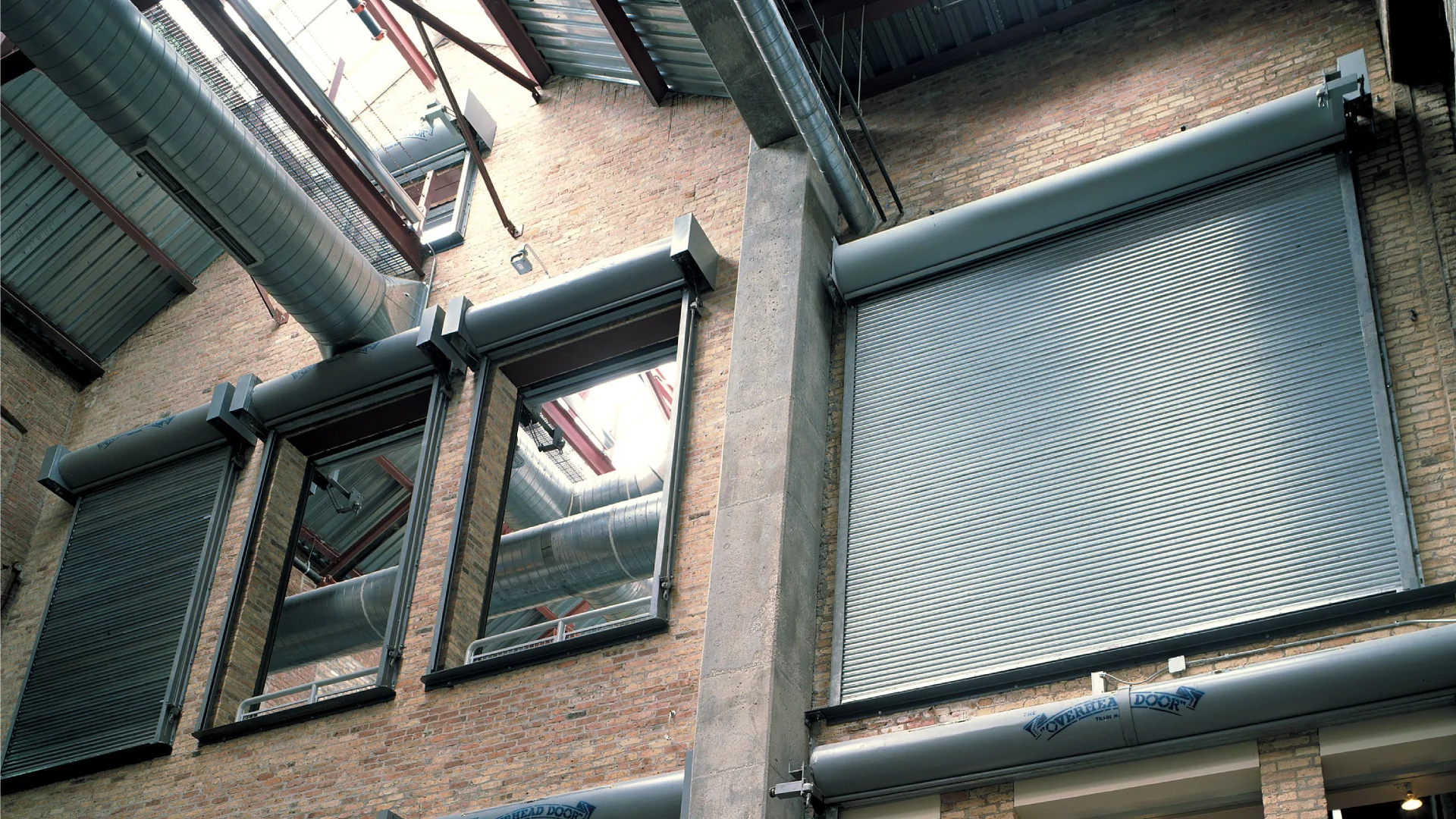 Rolling steel fire-rated doors installed in a commercial setting, showcasing compliance with fire safety standards and aesthetic design.