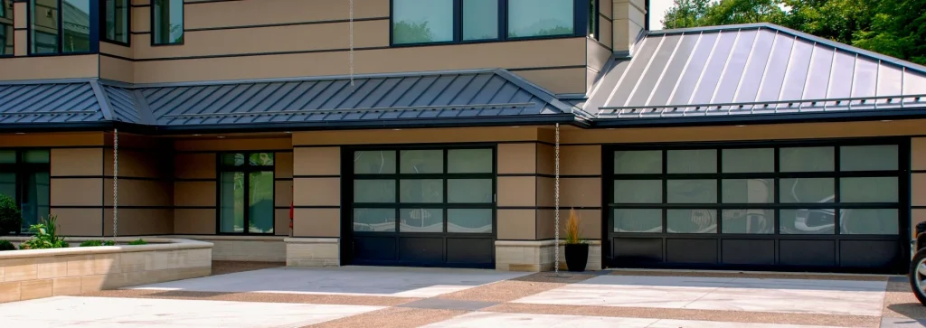 Modern garage doors with glass panels and black frames, showcasing energy-efficient design for residential properties.